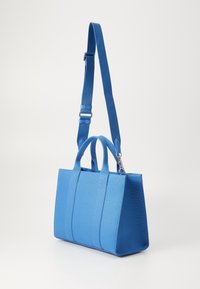 Borsa a mano in tessuto blu con due manici superiori e una tracolla regolabile. Presenta un design strutturato e una superficie liscia.