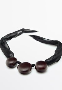 Collana in raso nero con tre grandi perle lucide, di colore marrone scuro, dalle forme morbide e con leggere variazioni di dimensioni.