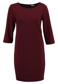 Bordó šaty ke kolen s ribbed texturou, výstřihem do lodičky, tříčtvrtečními rukávy a zapínáním na zip na zadní straně.