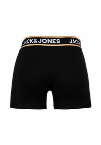 Boxers noirs avec une ceinture élastique arborant "JACK & JONES" en blanc et avec des accents dorés. Le tissu semble lisse et extensible.