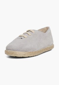 Chaussure en daim gris clair avec un bout arrondi, lacets beiges et semelle en jute tressé. Présente un design à découpe basse avec des détails de couture minimaux.