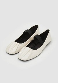 Ballerine in ecopelle bianca con punta rotonda, pieghe frontali e una fascia elastica nera sul collo del piede. Interno morbido.