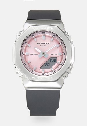 Reloj G-SHOCK con caja de acero inoxidable plateada, esfera rosa, correa de goma negra, pantalla analógica y digital, y resistencia al agua de hasta 20 bar.