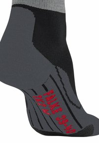 Calzini grigi e neri con talloni e punte rinforzati. Presentano testo rosso e righe per un ulteriore dettaglio di design. Texture in tessuto lavorato a maglia.