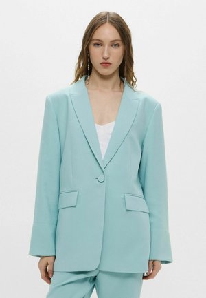 Blazer verde menta con un design strutturato, chiusura a un bottone, rever con allacciatura e tasche laterali. Tessuto liscio con una vestibilità su misura.