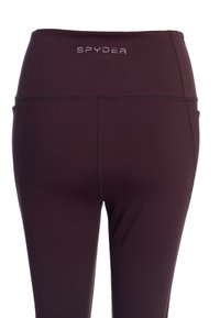 Burgunderfärgade träningstights med hög midja, med en vit "SPYDER"-logotyp på baksidan, slät textur och ingen synlig hårdvara.
