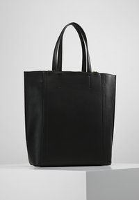 Czarna torba tote z ekoskóry o strukturalnym designie, z dwoma uchwytami i zapięciem na zamek. Gładka tekstura z minimalnym wyposażeniem i akcentami.