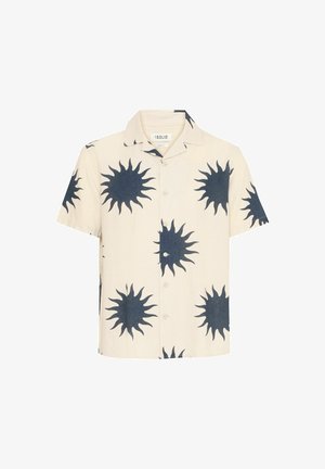 Korte mouwen overhemd van crèmekleurige stof met grote marineblauwe zonnestraalpatronen. Heeft een knoopsluiting aan de voorkant en een klassieke kraag.