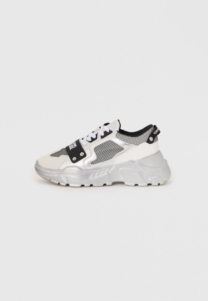 Chunky sneakers med hvit- og sølvdesign. Har meshpaneler, svarte detaljer og hvite snøringer. Teksturert såle med hevet mønster.