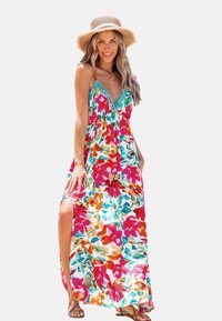 Robe maxi à motif floral avec des couleurs rouge, rose et turquoise. Elle possède un décolleté en V, des bretelles ajustables et des fentes sur les côtés pour la ventilation.