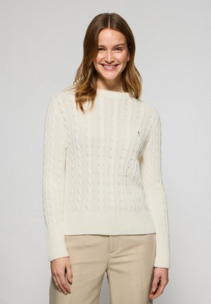 Maglione crema a trecce con orlo e polsini a coste. Tessuto morbido, scollatura rotonda, con un piccolo logo ricamato sul petto.