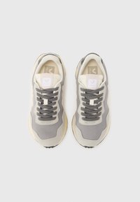 Gray mesh and suede sneakers with cream accents, featuring thick laces and a rounded rubber sole. Logo displayed on tongue.
