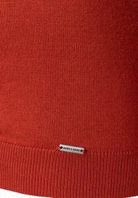 Rode gebreide trui met een gestructureerd oppervlak, voorzien van een ribgebreide zoom en een zilveren label onderaan met de tekst "MORE & MORE".