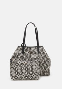 Sac tote structuré avec poignées synthétiques noires, présentant un corps en textile à motif losange noir et blanc et une pochette zippée amovible.