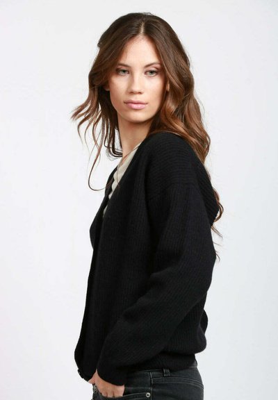 Cardigan nero lavorato a maglia con vestibilità ampia, scollo profondo a V e maniche lunghe. Il tessuto ha un aspetto strutturato e presenta un motivo a coste sottile.