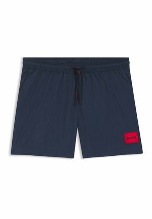 Costume da bagno blu navy con vita elasticizzata e coulisse, caratterizzato da una toppa rettangolare rossa con la scritta "HUGO" sulla gamba sinistra.