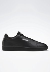 Černé kožené tenisky s hladkým povrchem, plochou gumovou podrážkou, kulatou špičkou a bílým logem Reebok na boku a jazyku.