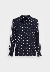 Blusa a maniche lunghe blu navy con pois bianchi. Presenta un colletto e strisce bianche decorative lungo le maniche. Realizzata in tessuto leggero.