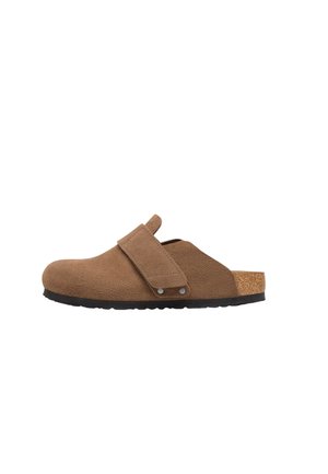 Zoccolo in camoscio marrone con ampia fascia regolabile, soletta in sughero e suola nera strutturata, mostrato di profilo su sfondo bianco.