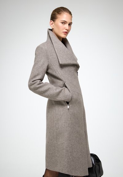Cappotto di lana grigio chiaro con colletto ampio, due tasche laterali e una silhouette aderente. Gli accenti con cerniera sulle tasche arricchiscono il design.