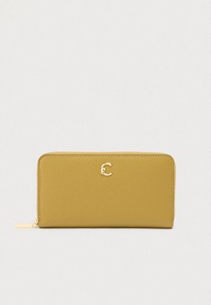 Gele leren portemonnee met een gestructureerde afwerking, voorzien van een gouden letter 'C' logo aan de voorkant. Ritssluiting met zilverkleurige metalen accenten.