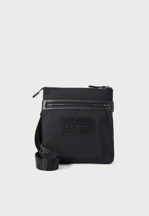 Bolsa cruzada rectangular negra con bolsillo frontal con cremallera, parche con el logo de Armani Exchange y correa ajustable con la marca, presentada sobre fondo blanco.