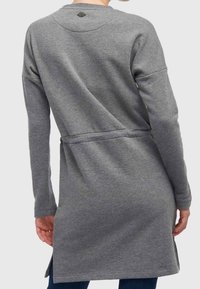 Cardigan gris de manga larga, confeccionado en material suave, que presenta una cintura ceñida con cinturón, aberturas laterales y un respaldo redondeado con un pequeño logotipo cerca del cuello.