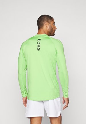 Camisa deportiva de manga larga, de color verde brillante, con el texto negro "BORG" en la parte trasera, hecha de una tela suave y ligera. Cuenta con un cuello redondo.