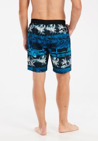 Blauwe en zwarte zwembroek met palmboom patroon, elastische tailleband en twee zijzakken. Korte lengte, lichtgewicht stof met een gladde textuur.