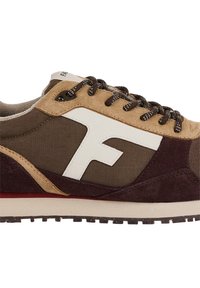 Sportschuh mit einem oberen Teil aus braunem Canvas und beigen Wildlederakzenten, einem großen weißen Logo und einem dunkelvioletten unteren Bereich. Schnürsenkel in Schwarz und Weiß.