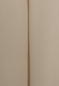 Tessuto di cotone beige con una trama strutturata, mostra due sezioni distinte con una leggera lucentezza e lievi pieghe lungo i bordi.