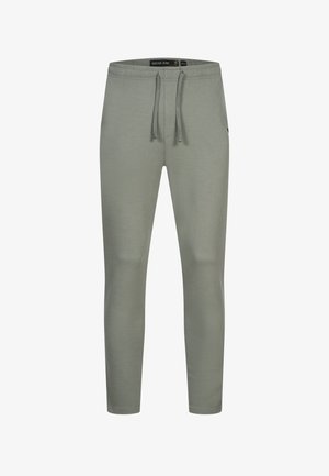 Pantaloni della tuta grigio chiaro realizzati in tessuto morbido, dotati di vita elasticizzata con cordino, tasche laterali e gambe affusolate.