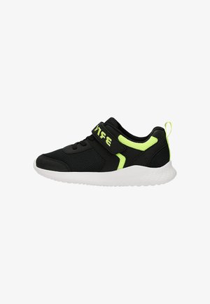 Chaussure de sport noire avec des accents vert néon, semelle blanche texturée et fermeture à bride avec texte vert inversé sur fond blanc.