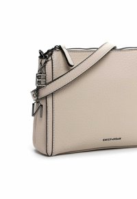 Beige textured leather crossbody bag with a black outline, featuring a zip closure, adjustable strap, and metal hardware accents.