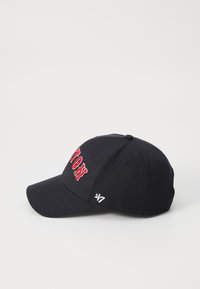 Black cap with red embroidered text. Features a curved visor, structured crown, and small logo on the side. Fabric has a smooth texture.