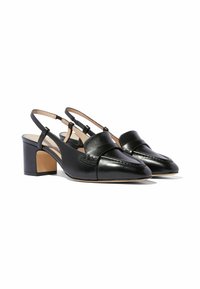 Zapatos de cuero negro tipo slingback con punta afilada, tira curvada y tacón bloque. Presentan un detalle de costura a lo largo de la parte superior.
