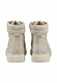 Bottines en daim beige avec un revers, forme arrondie et semelle en caoutchouc texturé. Équipées d'un étiquetage arrière pour un enfilage facile.