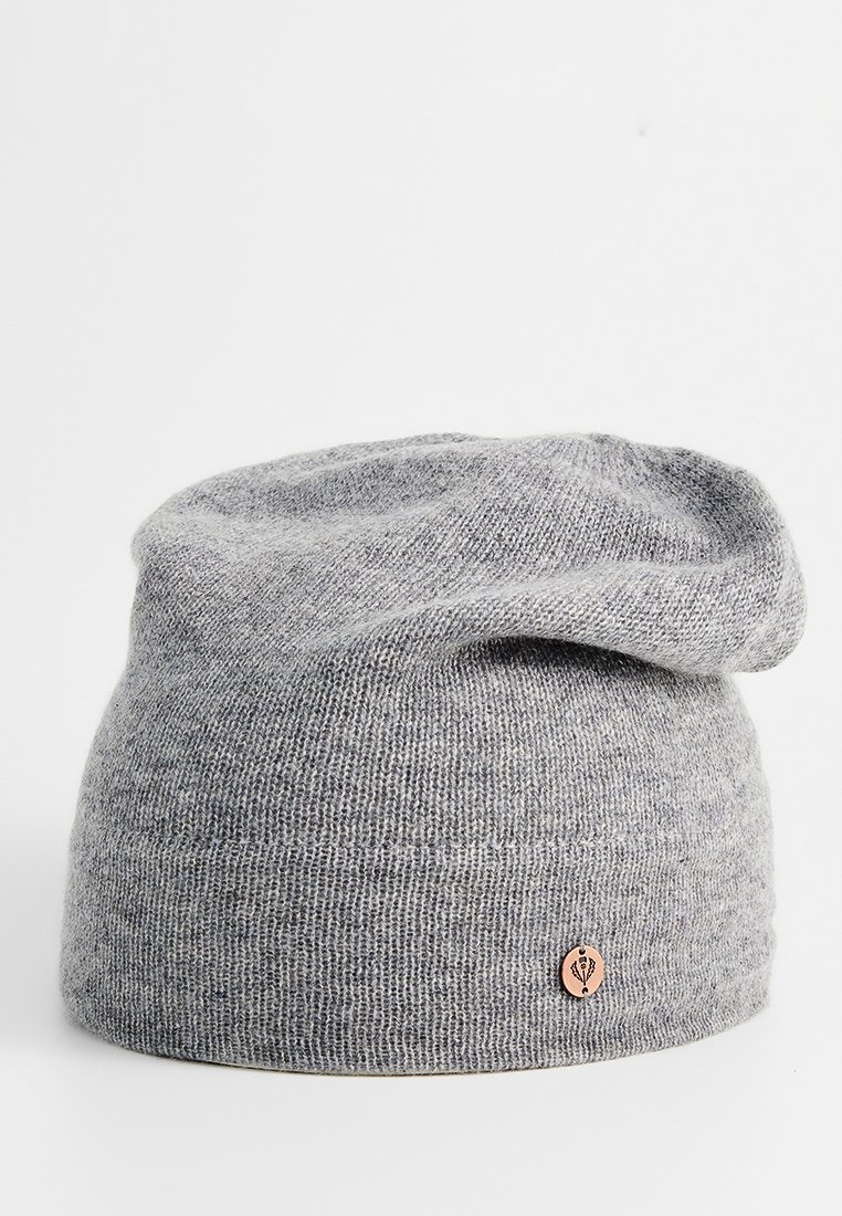 Szary dzianinowy beanie wykonany z miękkiego materiału, charakteryzujący się luźnym krojem oraz małą, okrągłą metką logo w jasnobrązowym kolorze z boku.