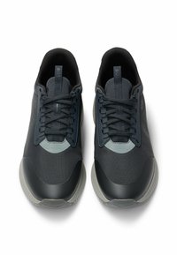 Scarpe sportive grigio scuro con parte superiore testurizzata, design con lacci e suola in gomma liscia e a contrasto con forma arrotondata.