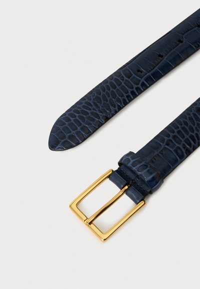 Ceinture en cuir bleu foncé avec un motif crocodile et une boucle rectangulaire dorée brillante sur un fond clair.