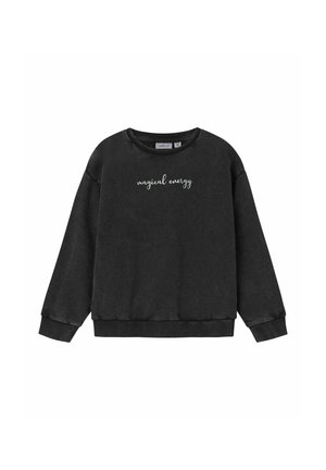 Svart sweatshirt med lång ärm, ribbad halsringning och ärmslut, samt vit kursiv text som säger "magisk energi" på framsidan.