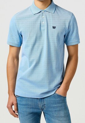 Hellblaues kurzärmeliges Poloshirt mit feinem Streifenmuster, klassischem Kragen und kleinem Logo auf der linken Brustseite.
