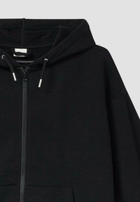 Czarna bluza zapinana na zamek z kapturem ze sznurkiem, przednia kieszeń typu kangur oraz teksturowany materiał. Prosty design z metalowymi akcentami zamka.