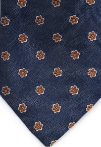 Donkerblauwe stropdas met een gestructureerde stof, voorzien van verspreide kleine oranje en witte bloemmotieven. Toeloopende uiteinden met een puntige tip.