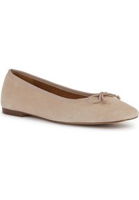 Ballerine in suede beige con punta arrotondata, suola sottile marrone e un fiocco decorativo sulla parte anteriore. Texture liscia e dettagli minimi.