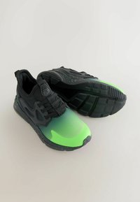 Zwart-groene sneakers met een verloopontwerp, een gestructureerde zwarte overlay, vetersluiting en een zwart gevlekt zool. Rubberen buitenzool voor grip.