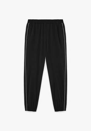 Mustat verkkarit joustavalla vyötärönauhalla ja resoreilla, joissa sivuilla vetoketjulliset taskut ja valkoiset tehosteet ulkosaumoissa.