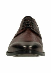 Donkerbruin gepolijst leren schoen met zwarte veters, gezien vanuit de voorkant tegen een witte achtergrond.