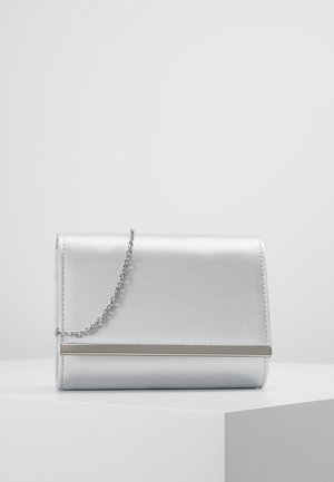 Lille sølv clutch med en tynd kæderem og metalstang detalje foran, placeret på en hvid overflade.