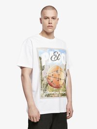 T-shirt en coton blanc avec un graphique coloré d'un design de basket-ball et du texte. Manches courtes, coupe décontractée, avec des coutures d'épaule visibles.